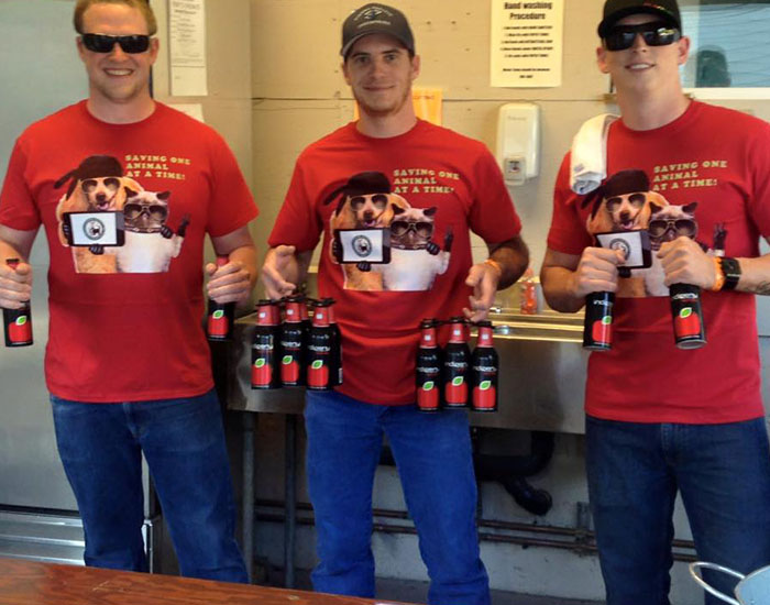 guys grabbing bottles of cider